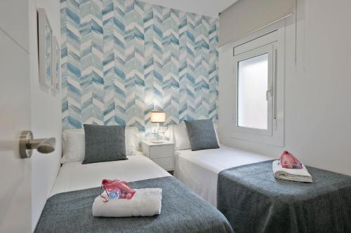 バダロナにあるAlcam Badalona Roger 2のベッド2台と窓が備わるホテルルームです。