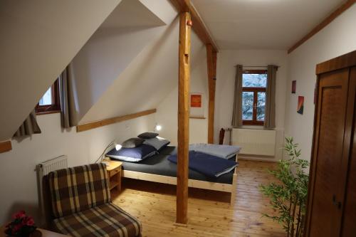 ein Schlafzimmer mit einem Bett und einem Stuhl im Dachgeschoss in der Unterkunft Prázdninový dům Jirkov in Železný Brod