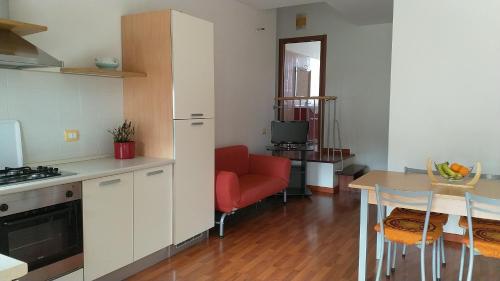 ムラヴェーラにあるAppartamento Panoramaのキッチン、リビングルーム(赤いソファ、テーブル付)