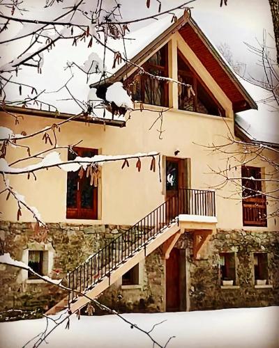 une maison avec un escalier dans la neige dans l'établissement Le Chat Perché - Appartements 3 étoiles spacieux et chaleureux à Allemond, à Allemont