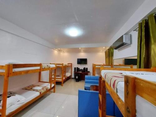 a room with two bunk beds and a tv at Casa de Robles Tanay Rizal in Tanay
