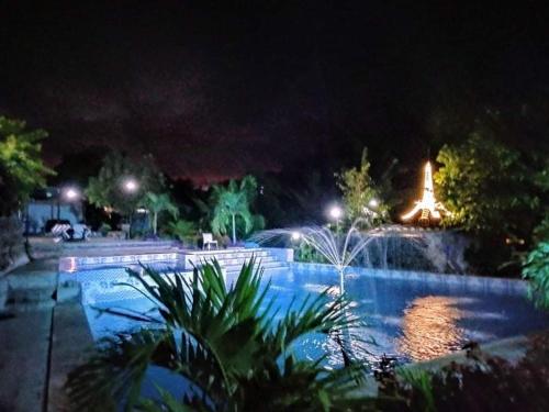 uma piscina com uma fonte à noite em Casa de Robles Tanay Rizal em Tanay