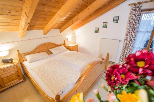 a bedroom with a bed and flowers in a room at Landhaus Fürberger in Anger