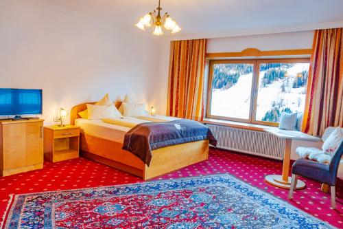 a bedroom with a bed and a large window at Pension Südhang in Bad Kleinkirchheim