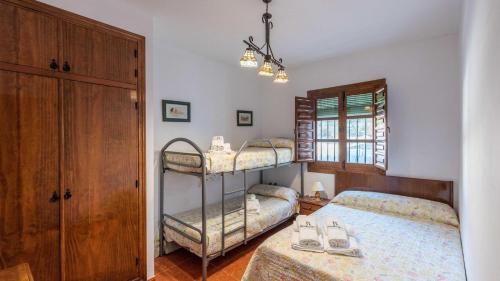 sypialnia z dwoma łóżkami piętrowymi i oknem w obiekcie Las Casitas de los Cano Archidona by Ruralidays w mieście Archidona