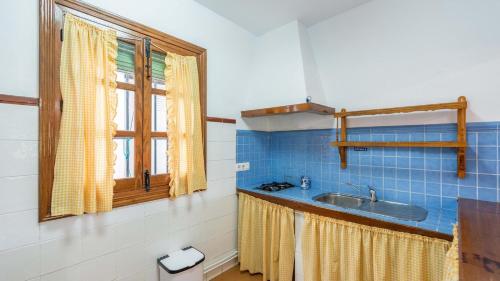 ein Bad mit einem Waschbecken und einem Fenster in der Unterkunft Las Casitas de los Cano Archidona by Ruralidays in Archidona