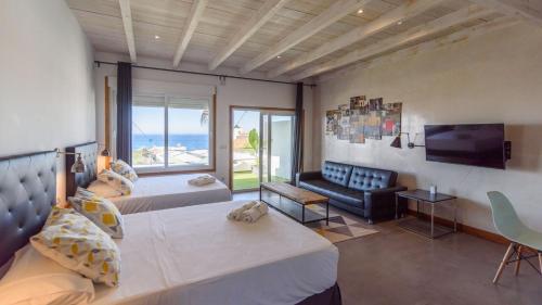 a bedroom with two beds and a couch and a television at Torre Vigía Torrox by Ruralidays in Torrox