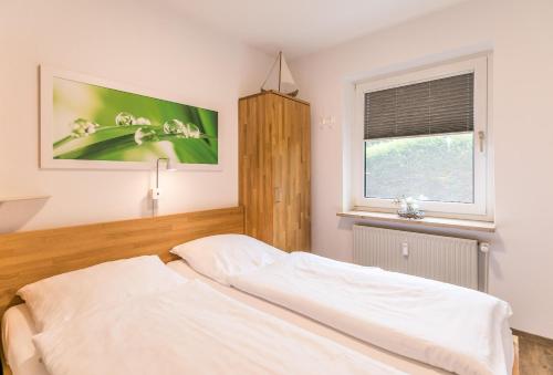 a bedroom with a bed and a window at "Ferienwohnug Bambergers" Ferienwohnung Bamberger s in Büsumer Deichhausen