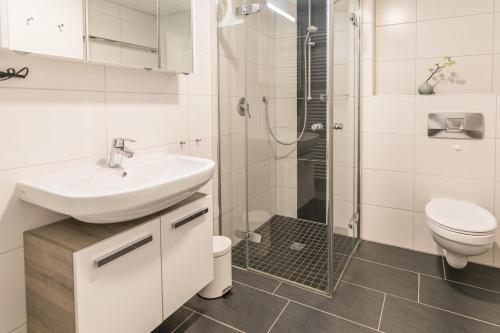 a white bathroom with a sink and a shower at "Ferienwohnug Bambergers" Ferienwohnung Bamberger s in Büsumer Deichhausen