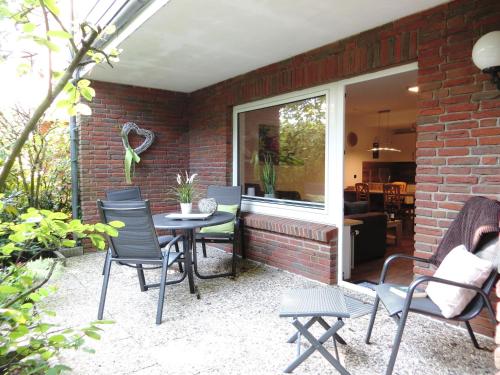 a patio with a table and chairs next to a brick wall at "Ferienwohnug Bambergers" Ferienwohnung Bamberger s in Büsumer Deichhausen