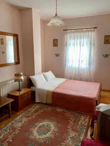 a bedroom with a large bed and a window at Eleni's Guesthouse in Pisoderi