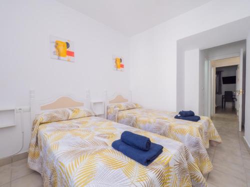 Dos camas en una habitación blanca con toallas azules. en Cubo's Dreams Alhaurin Room 2, en Alhaurín el Grande