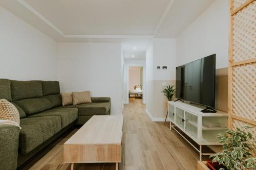 a living room with a couch and a flat screen tv at Natural Stay Apartamentos PassivHaus in Logroño