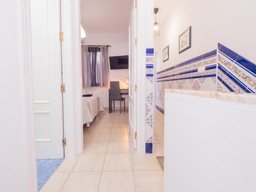 einen Flur mit blauen und weißen Fliesen an der Wand in der Unterkunft Cubo's Dreams Alhaurin Room 4 in Alhaurín el Grande
