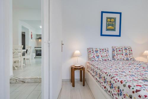 a bedroom with a bed and a table with a lamp at Casa Santos Nicolau in Setúbal