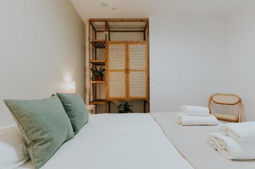 a bedroom with a white bed with towels on it at Natural Stay Apartamentos PassivHaus in Logroño