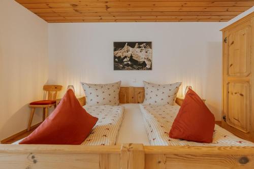a bed in a room with red pillows on it at Haus Wilma in Schruns