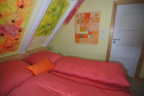 a red couch with an orange pillow in a room at Mini Beach House II in Rantum