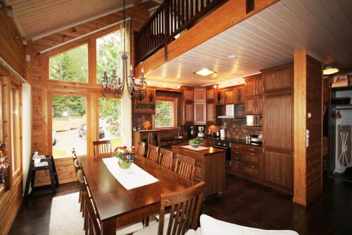 a large kitchen with a wooden table and chairs at Villa Joutsen in Hollola