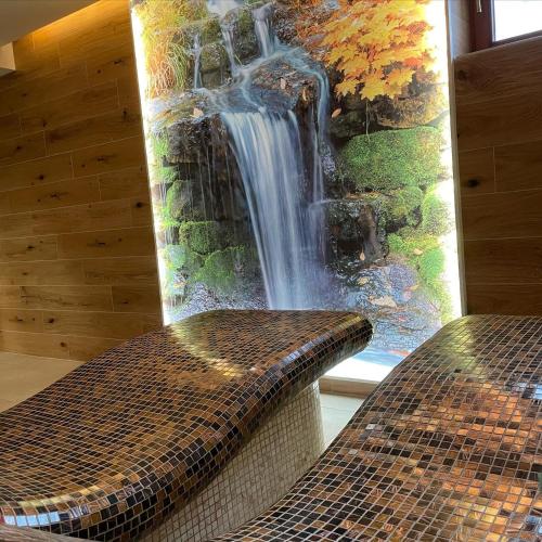 a view of a waterfall from a window with a bench at Penzión Solisko*** Oščadnica in Oščadnica