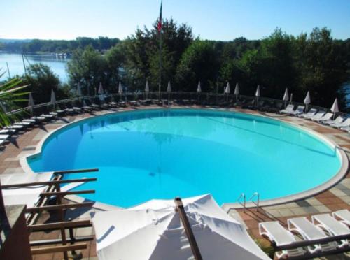 a large blue swimming pool with chairs and water at La Dolce Vita House Boat in Lisanza
