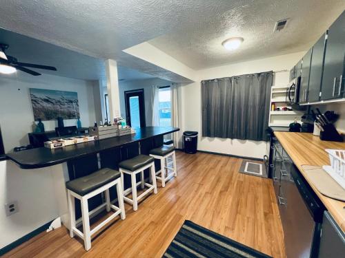 a kitchen with a bar and stools in a room at 5 Bedroom Lakeside Home Sleeps 12 - Shared Lake Access, Large Yard, Central Air, Fire Pit, Horseshoes & More! in Geneva