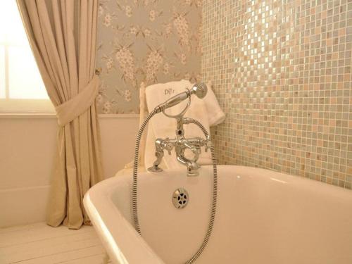 a bath tub with a faucet in a bathroom at The Duke of Bedford in Bedford