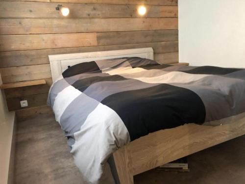 ミッデルケルケにあるDe Guillaumeの木製の壁の客室の大型ベッド1台分です。