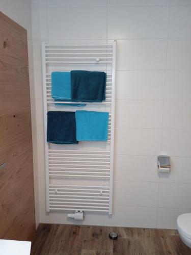 a towel rack in a bathroom with blue towels at Pernerhof in Aich