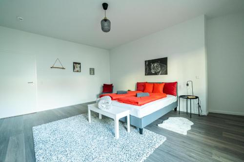 a bedroom with a bed with red pillows and a rug at FULL HOUSE Premium Apartments Dresden A6 in Dresden