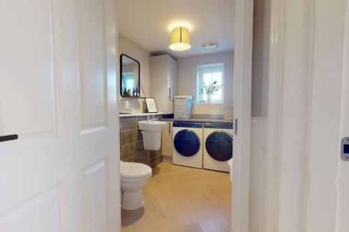 a bathroom with a toilet and a sink and a mirror at Magnolia House in Leamington Spa