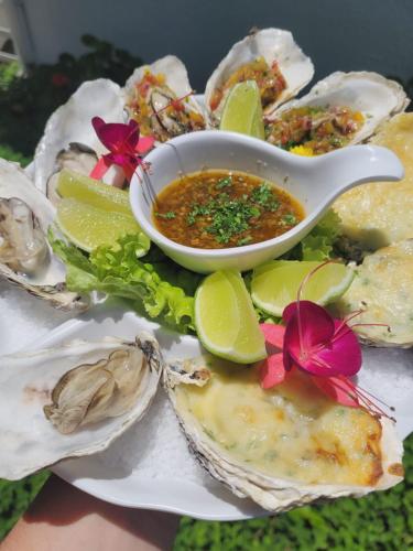 a plate of oysters with a bowl of dipping sauce at Hotel Sete Ilhas in Florianópolis