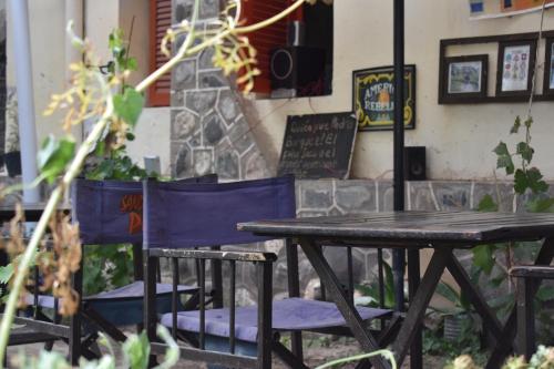 a wooden table and chairs sitting next to a table at La Enramada in Amaichá del Valle