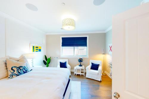 a bedroom with a large white bed and a window at Sunshine Beach Escape in Seal Beach