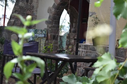 a wooden table and chairs next to a stone fireplace at La Enramada in Amaichá del Valle