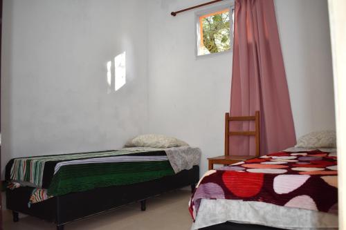 1 dormitorio con 2 camas y ventana en La Enramada in 