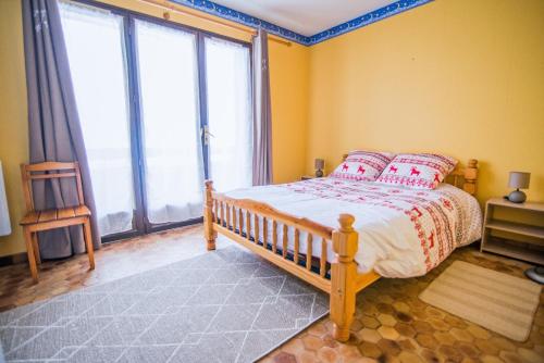 1 dormitorio con cama y ventana grande en Les Campanules, en Saint-Léger-les-Mélèzes