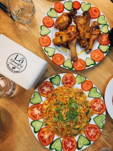 two plates of food on a wooden table at Lá Homestay in Mỹ Phước