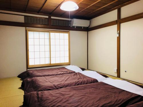 two beds in a room with two windows at Utatei Sou in Takayama