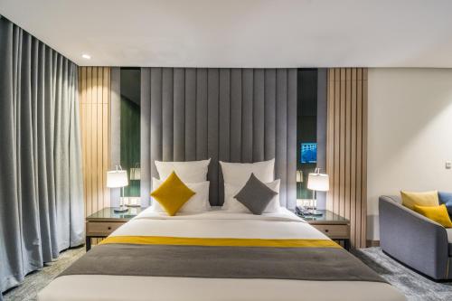um quarto com uma cama grande e um sofá em Erfad Hotel - Riyadh em Riade