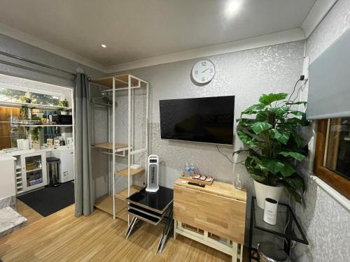 a living room with a clock on a wall at Tropical Style House Near Newcastle City Centre in Newcastle upon Tyne
