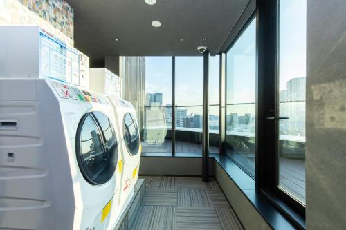 a room with a train in a building with windows at Mercure Tokyu Stay Osaka Namba in Osaka