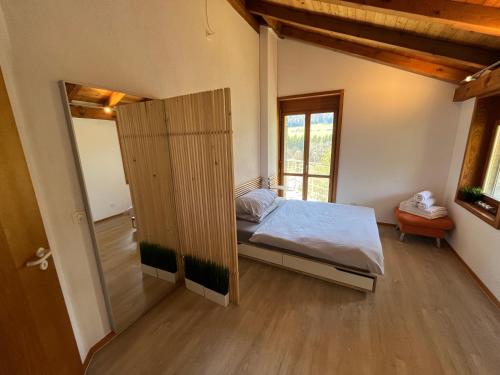 1 dormitorio con 1 cama y puerta corredera en the Jad B&B, en Comoret