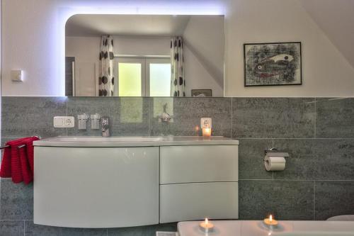 La salle de bains est pourvue d'un lavabo et d'un miroir. dans l'établissement "Schwedenhaus" Das Schwedenhaus, Whg Karlsson, à Büsum