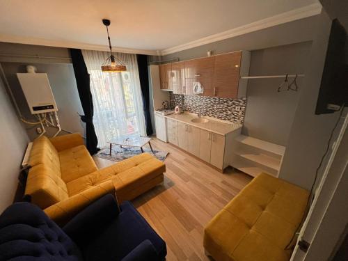 a living room with two couches and a kitchen at AYDOĞDU SUİT OTEL in Bolu