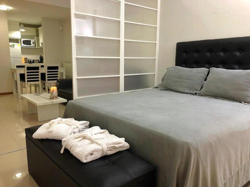 1 dormitorio con 1 cama grande y toallas en un banco en san telmo sos hermoso en Buenos Aires