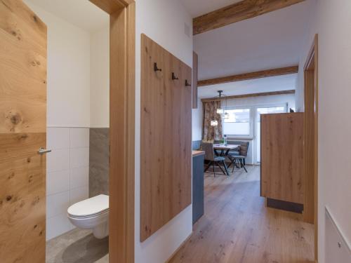 a bathroom with a toilet and a table at Alps Holaus in Aschau