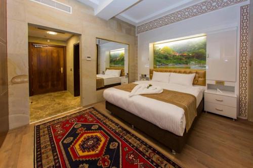 - une chambre avec un grand lit et un miroir dans l'établissement GHERDAN GOLD OTEL, à Konya