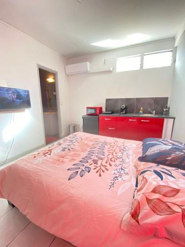 ein Schlafzimmer mit einem großen rosa Bett in einem Zimmer in der Unterkunft Joli studio proche de toutes commodités in Les Trois-Îlets