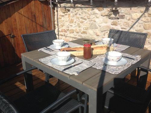 une table en bois avec trois tasses et des soucoupes, dans l'établissement Maison de charme en Provence, à Mirabel-aux-Baronnies
